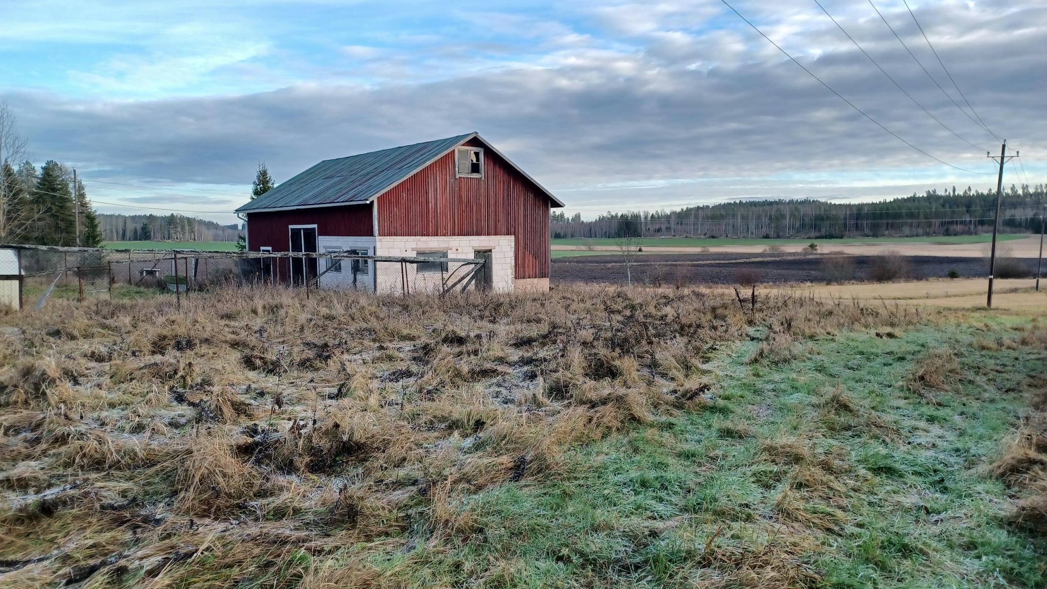 Pihapiirissä sijaitseva talousrakennus kuvattuna etuoikealta.