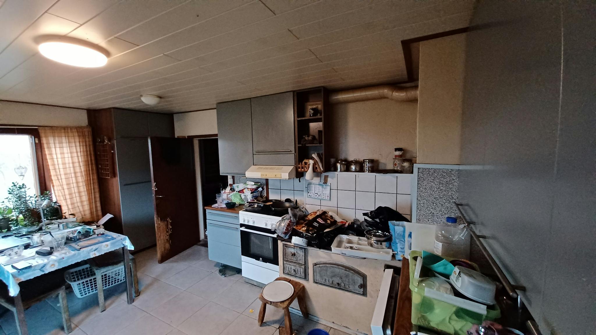 Keittiö ja ruokatila. Keittiössä on vanha puuhella.