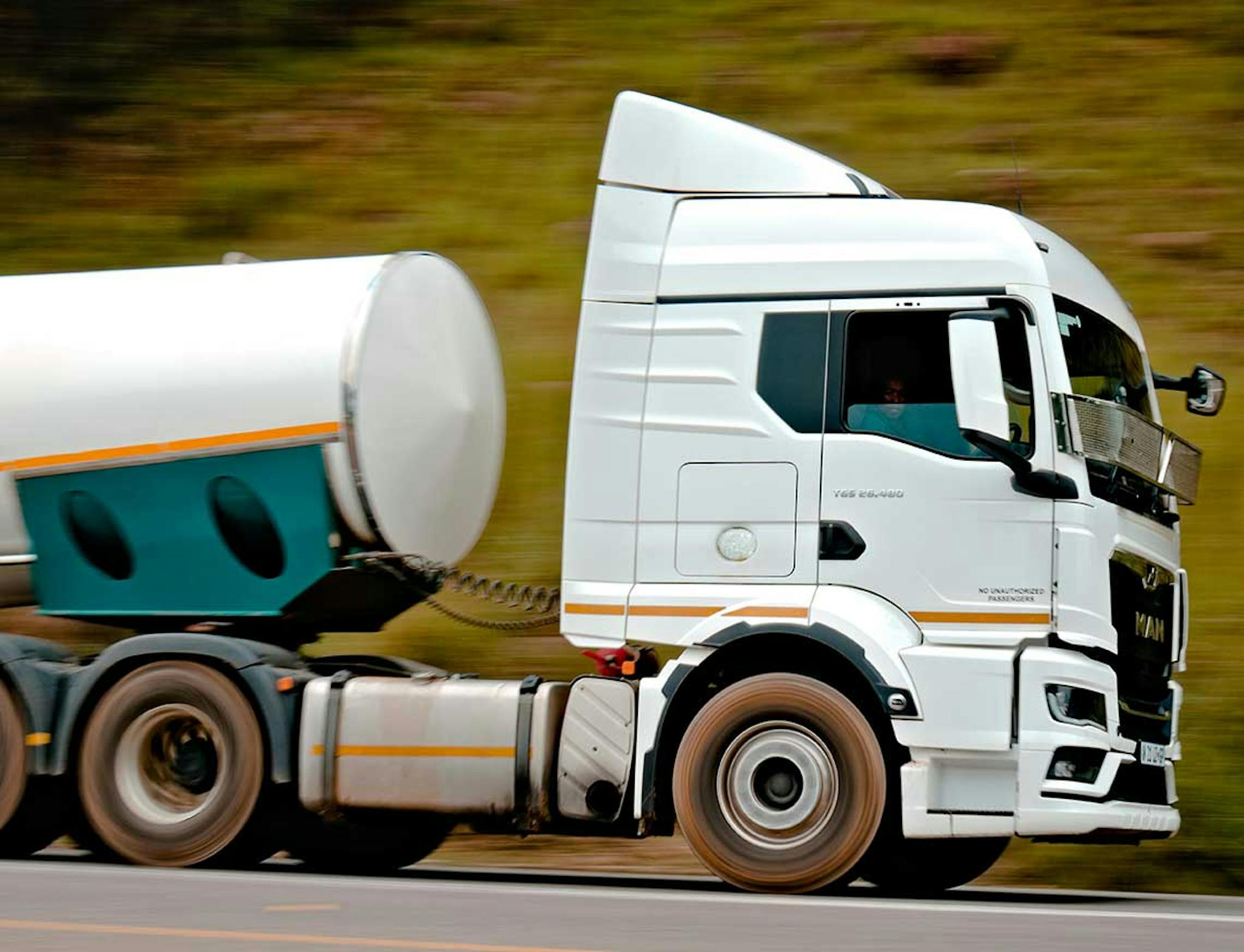 white truck driving fast on a road