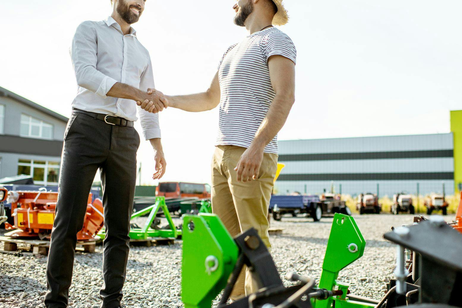 konekauppias ja maajussi kättelevät kaupat ulkona