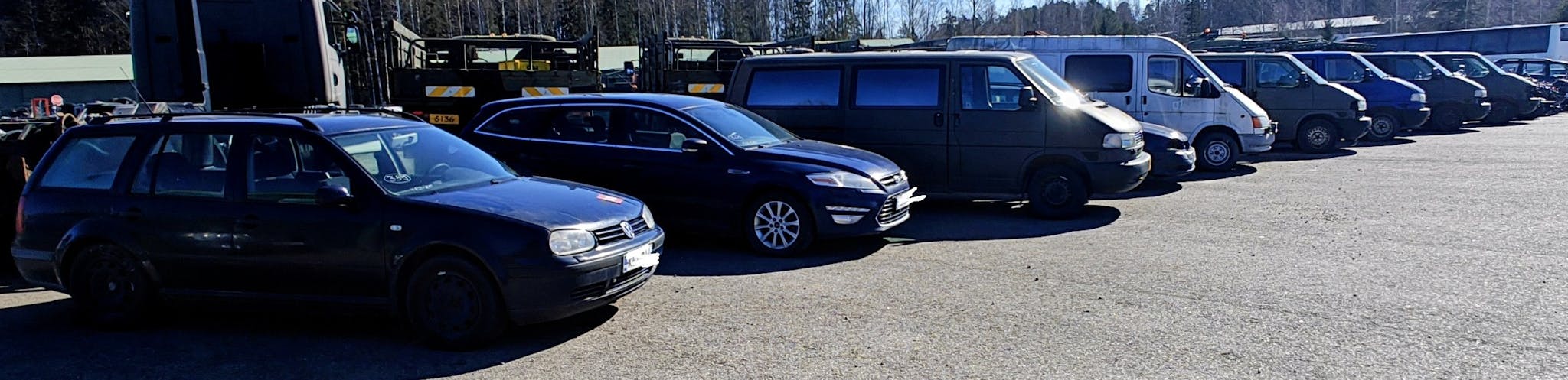 Henkilöautoja ja pakettiautoja rivissä