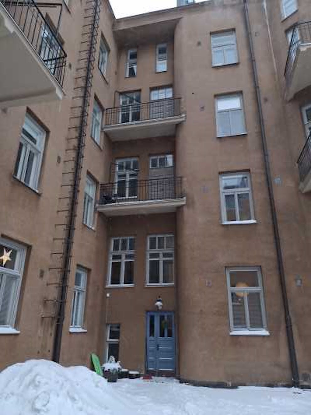 Kuva kerrostalon ulkopuolelta kohti sisäänkäyntiä