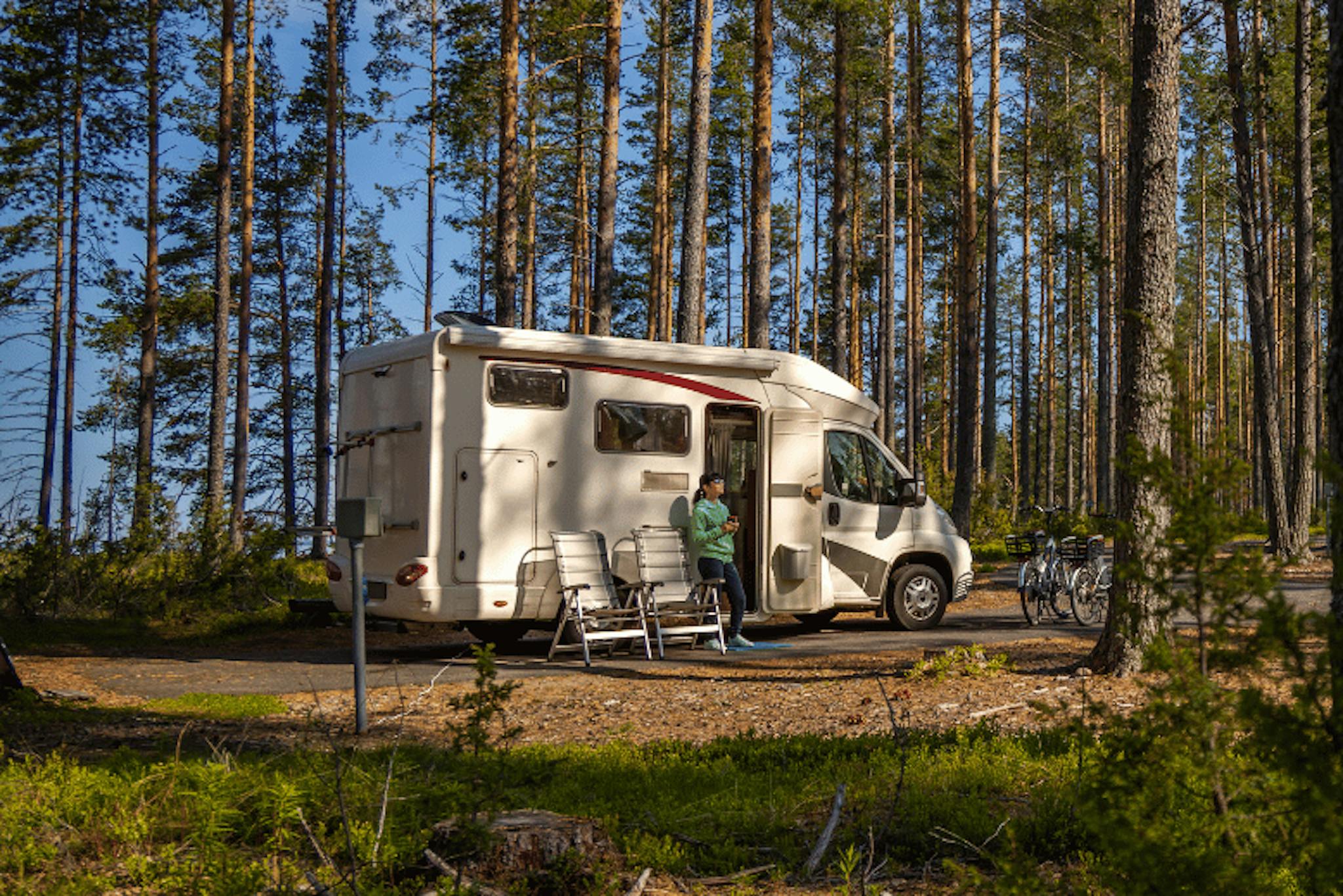 nainen karavaanissa metsän keskellä